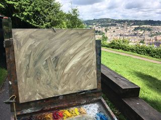 Canvas covered in ochre, set up in a park overlooking Bath city skyline