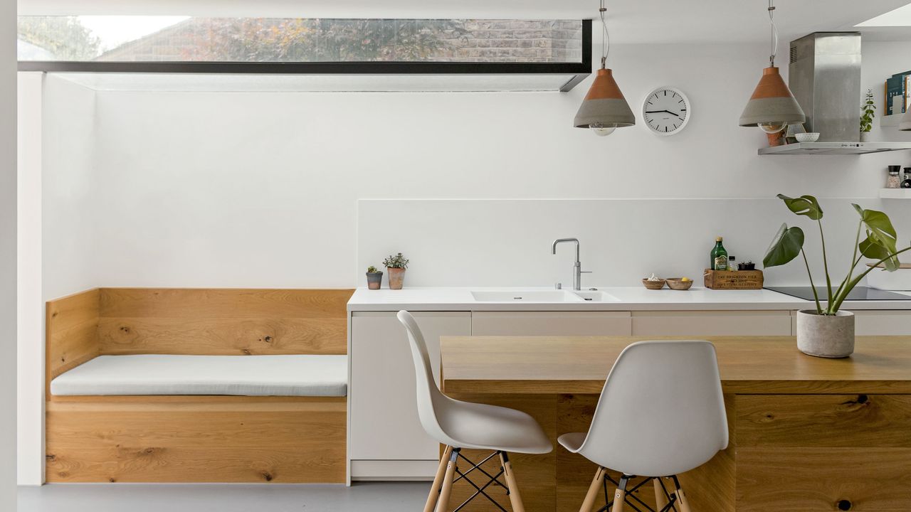 two-storey extension kitchen island breakfast bar Eames chairs white countertop wooden kitchen cabinets pendant lights