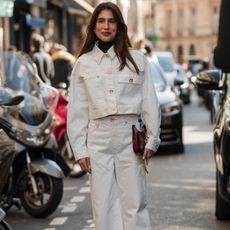 Woman in white denim jacket and white jeans GettyImages-2063528010 Listing