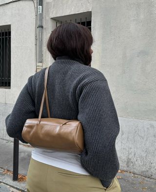 French woman wearing an east-west bag.