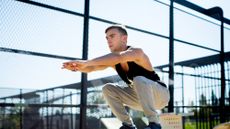 A man performing a squat jump outdoors