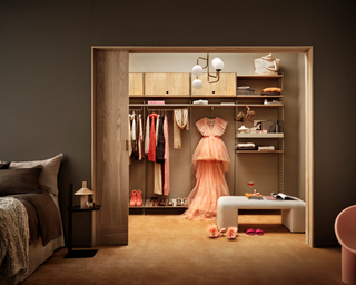 A warm brown master bedroom with walk in closet made up of metal modular shelving furniture by String Furniture