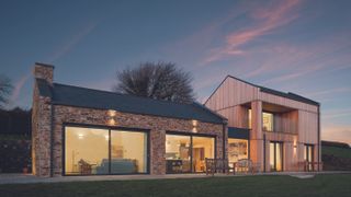 contemporary timber clad extension joined to existing stone house with glass link