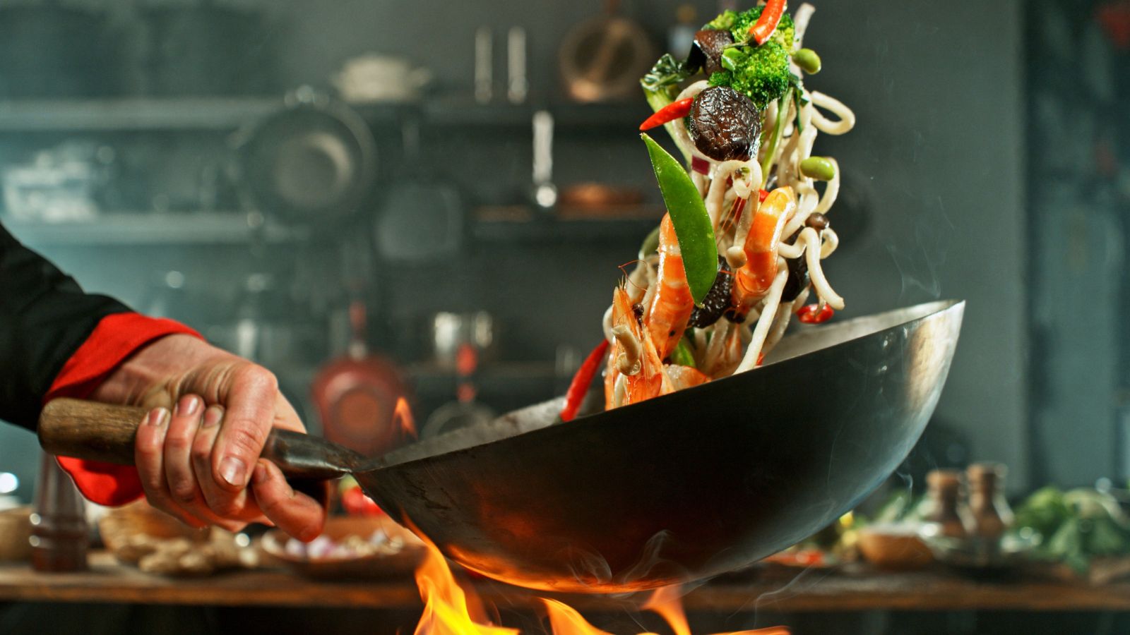Carbon steel wok tossing a stir fry in the kitchen 