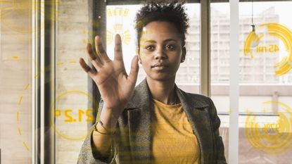 A businesswoman works with data on a clear glass wall.