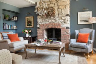 living room with sofa and armchair and brick fireplace