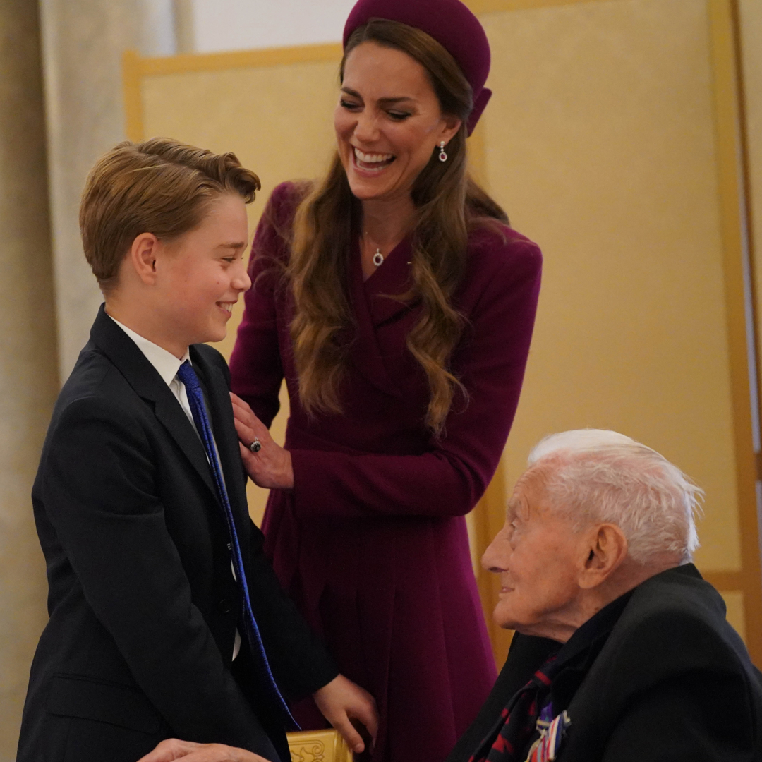Princess Kate laughing putting her arm on George&#039;s shoulder, who is chatting to a WWII veteran