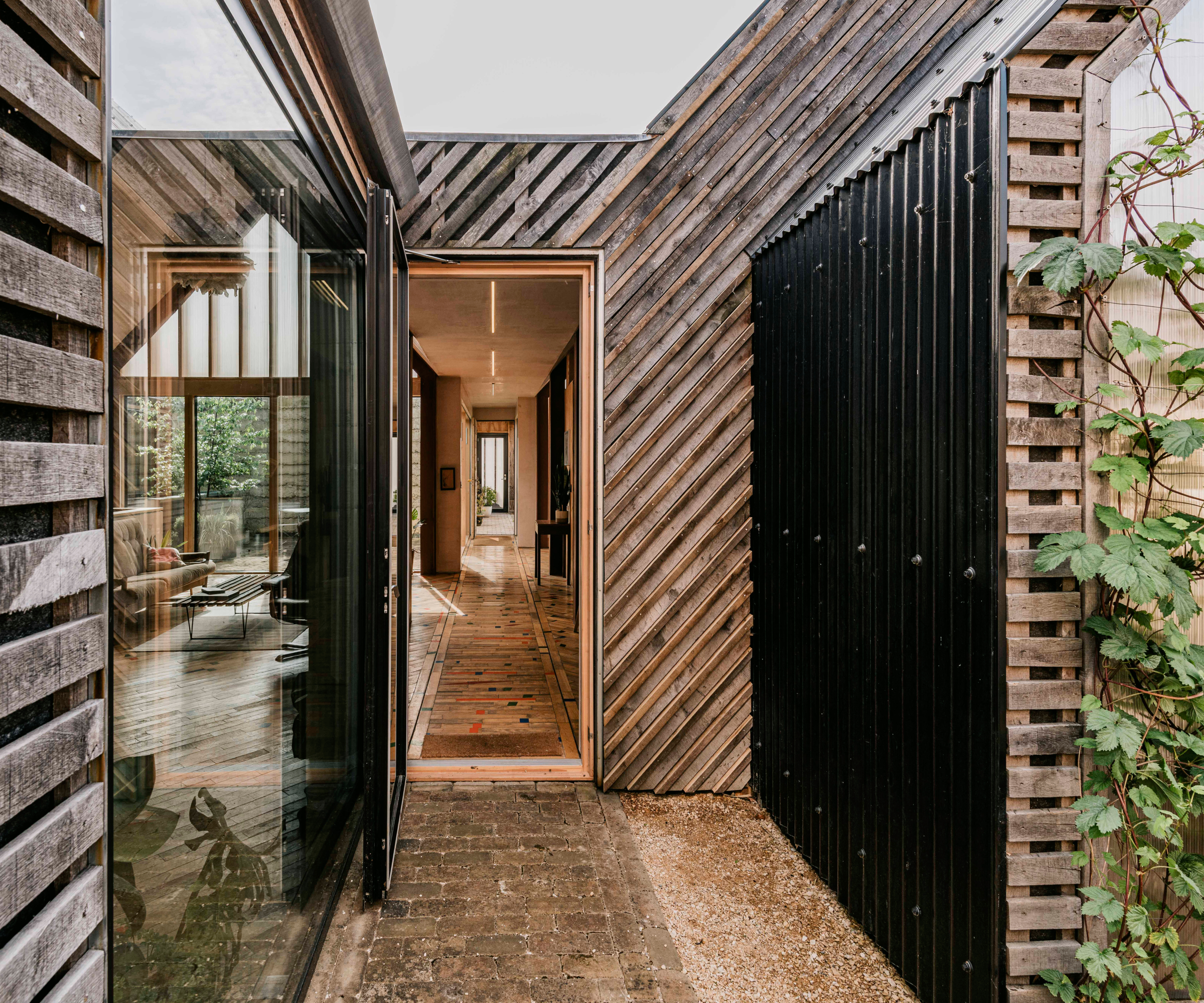 small internal courtyard with walls clad in timber and also black metal cladding