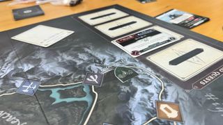 The Skyrim board game board and quest cards laid out on a wooden table