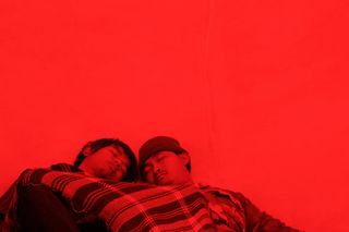 Red sepia & background with two people sitting close together