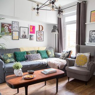 living room with white wall and sofa with cushions and wooden flooring