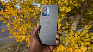 The OnePlus Nord N300 5G in hand next to a tree