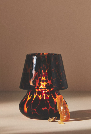 tortoiseshell mushroom lamp with the candle lit so it glows from within