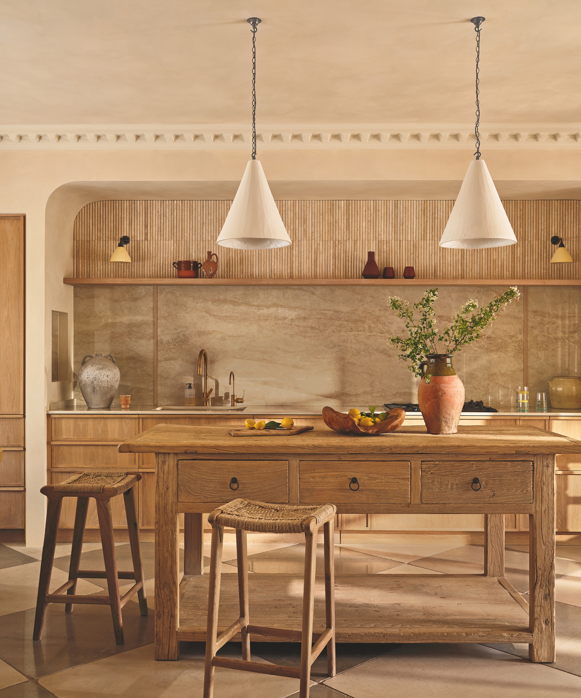 A Tuscan-inspired kitchen with a marble backsplash and a wooden freestanding island