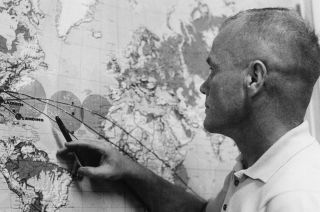 John Glenn reviews his orbital trajectory on a map the day after a launch scrub of his Mercury-Atlas 6 mission on Jan. 27, 1962.
