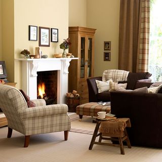living room with fireplace and armchair with stool