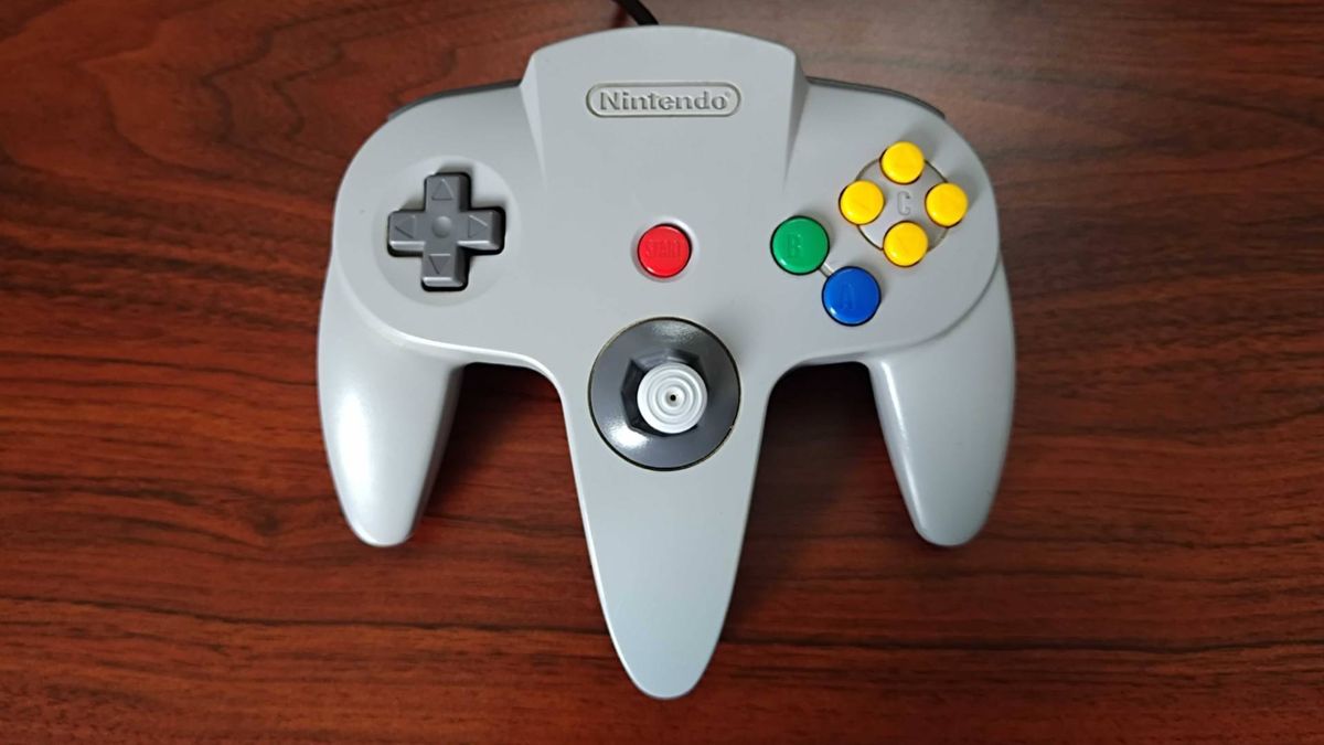 N64 controller before restoration on woodgrain desk.