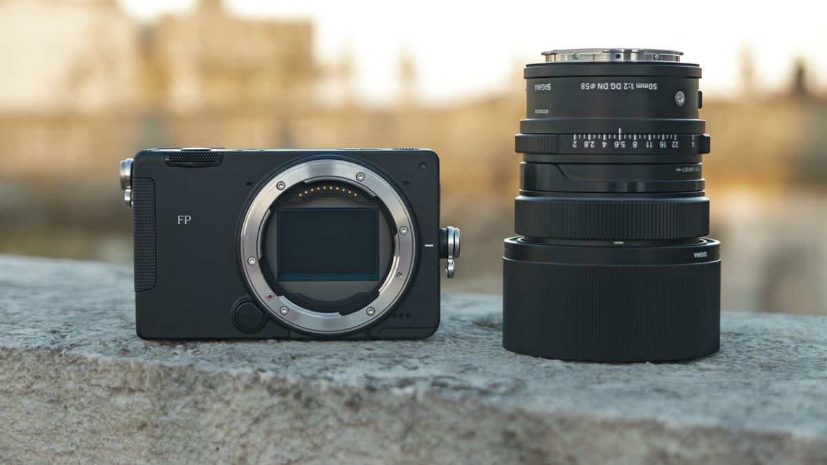 Sigma FP2 mirrorless camera alongside the 50mm f/2 contemporary lens they are placed on a marble wall, at golden hour