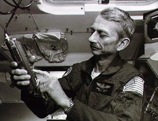 owen garriott holding a radio in the space shuttle