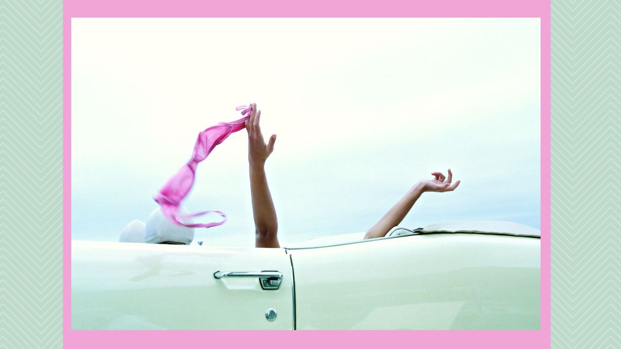 Young woman in convertible car, arms raised, holding bra, spontaneous sex