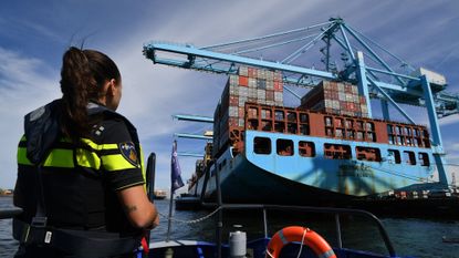 A port police officer observes a container ship arriving in Rotterdam's harbour in August 2022