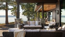 A veranda overlooking the sea on a modern home with outdoor sofas and an armchair. 