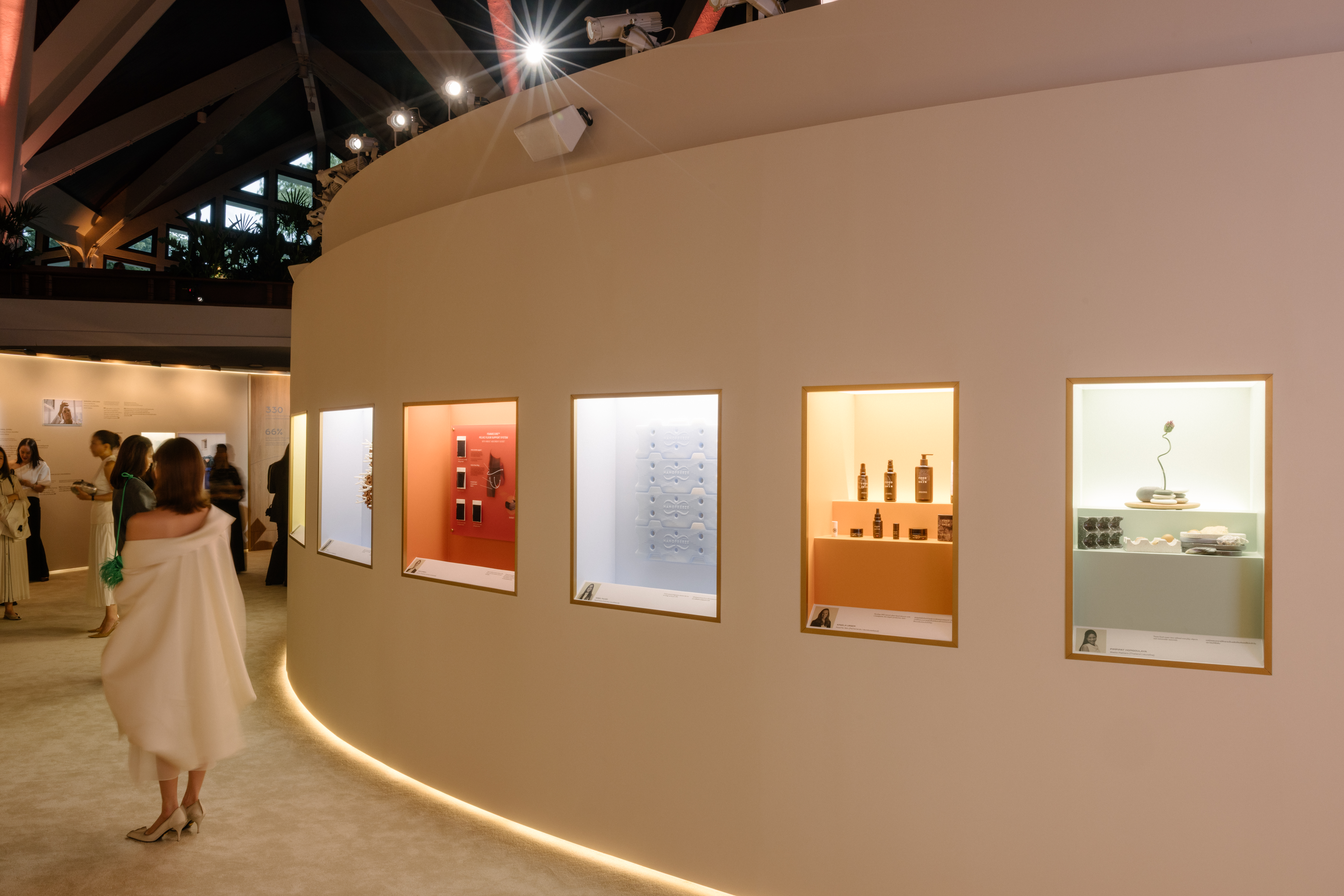 A softly lit room exhibiting former winners of the Cartier Women's Initiative.