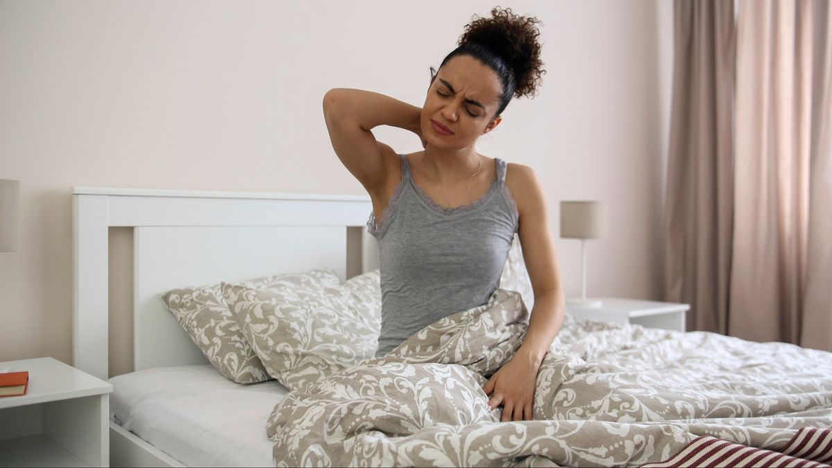 Woman with a stiff neck on bed