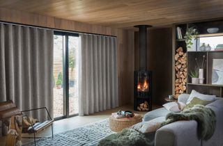A Scandinavian style living room with a wood burner and grey blinds