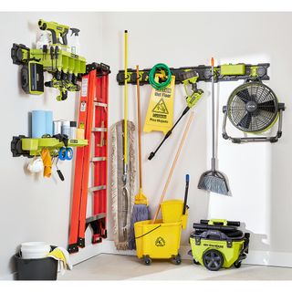 Garage wall with storage system and hanging tools, ladders, and appliances