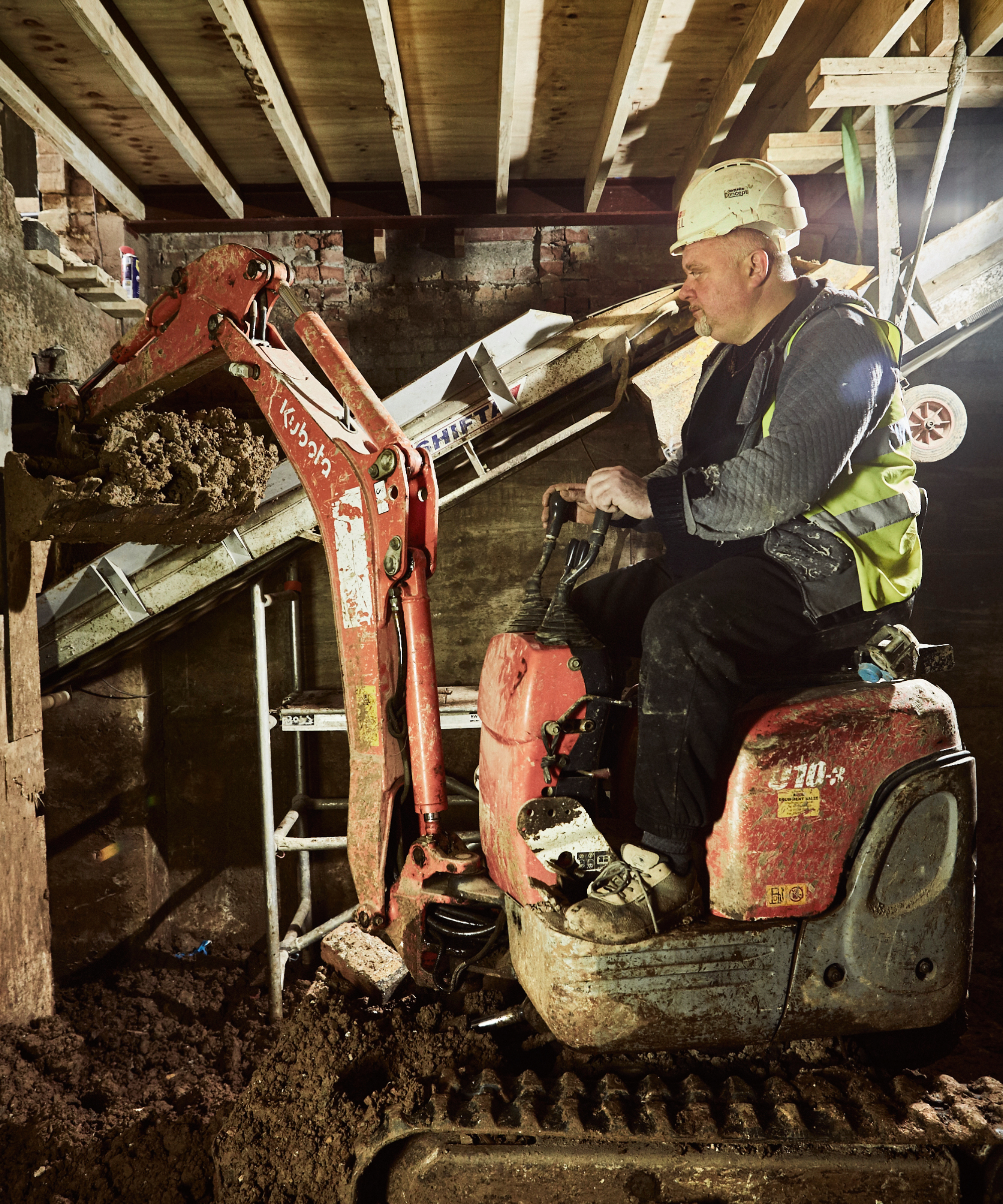 man on digger digging out basement conversion