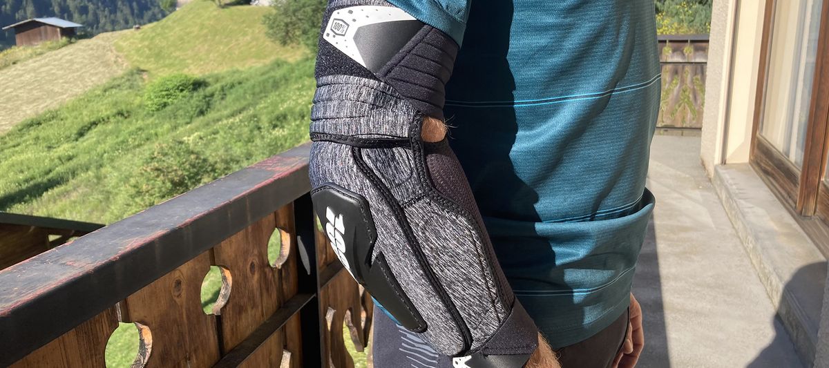 Closeup of man wearing elbow guard with countryside backdrop