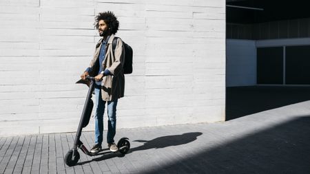 Man using an electric scooter on a pavement