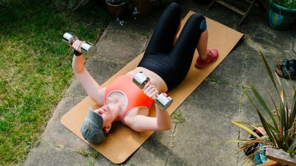 Woman doing floor chest press to learn how to do push-ups for beginners