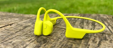 Suunto Sonic bone conduction headphones in lime on a wooden table