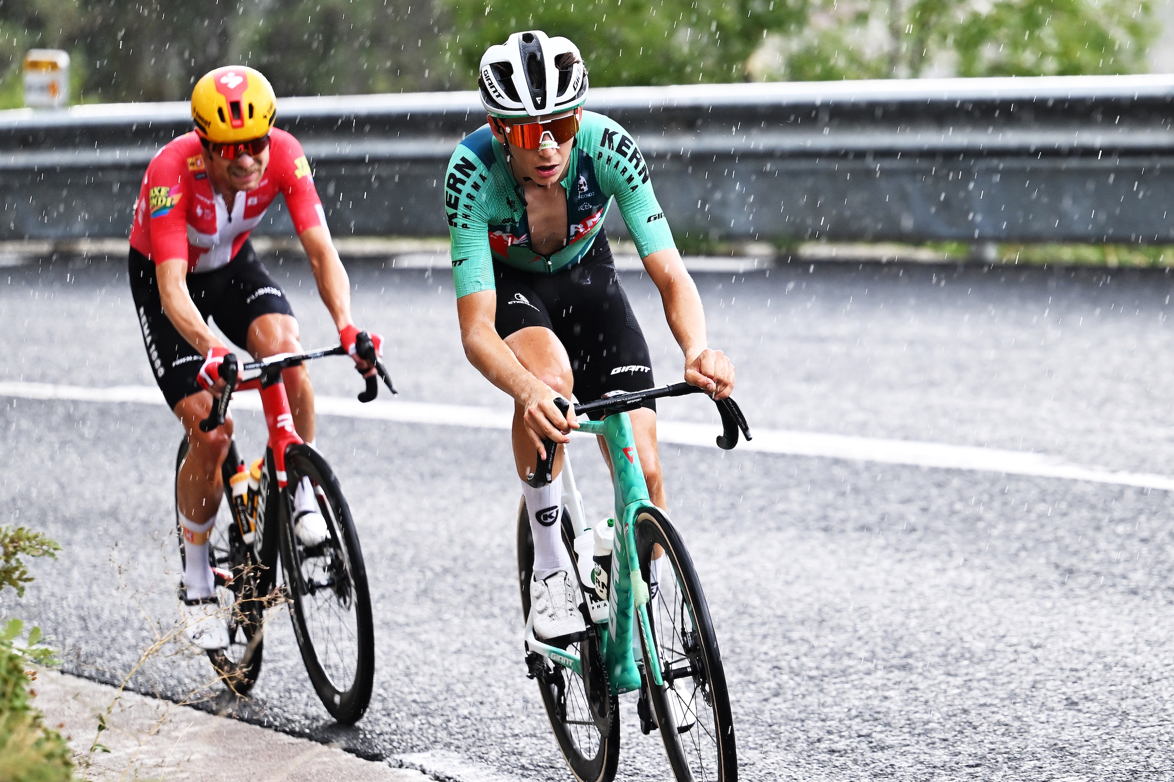Mats Wenzel (Kern Pharma) and Magnus Cort (Uno-X Mobility) riding as hail begins to accumulate on the road