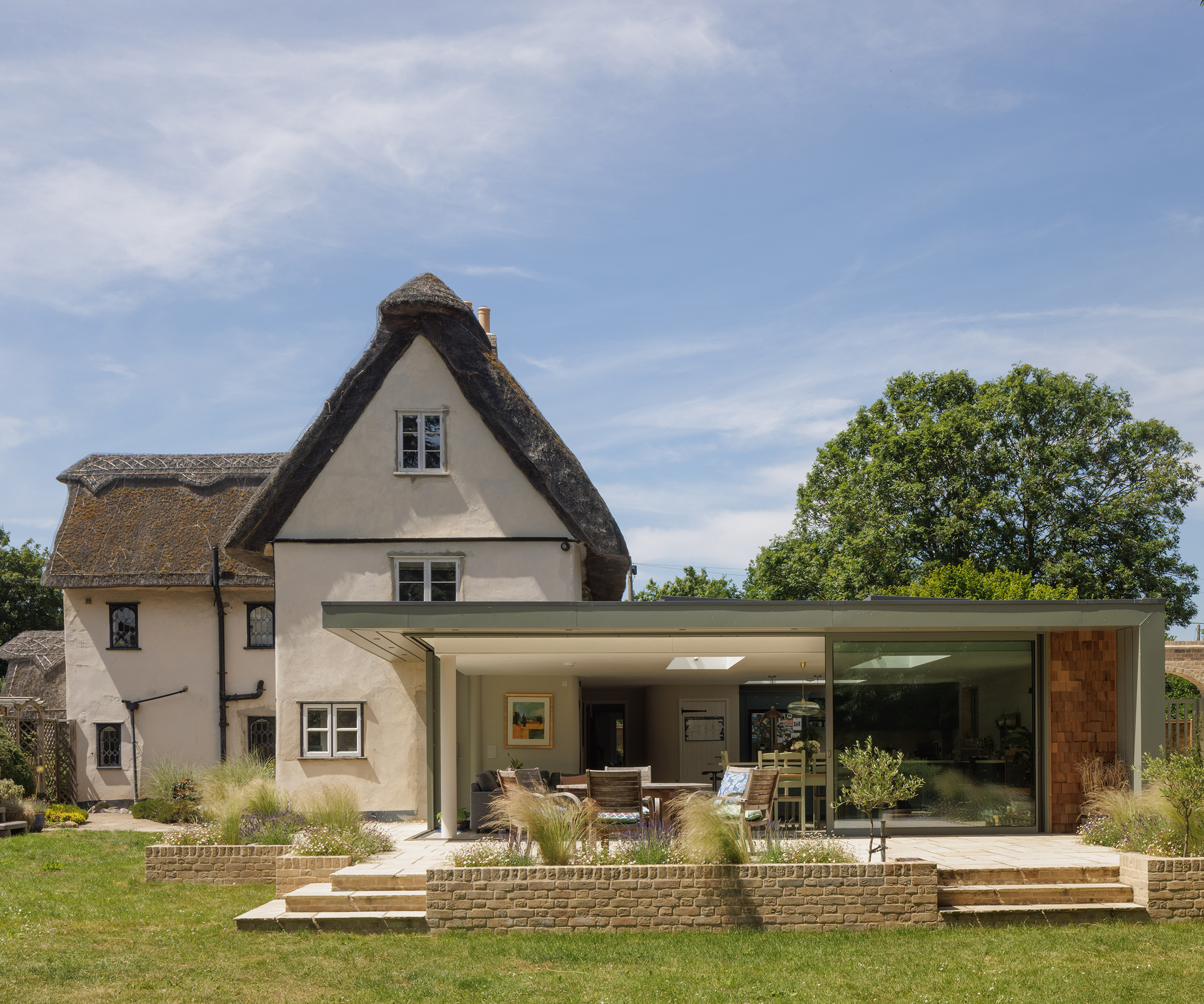 A traditional period thatched cottage with a contemporary glass extension and new patio