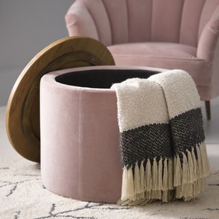 Pink storage footstool, open with blankets inside