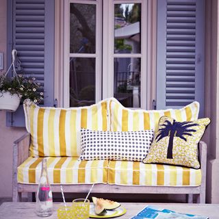 yellow striped outdoor sofa on garden pation with cushions