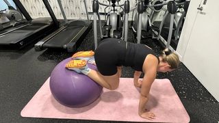 Woman performs gym ball knee tuck