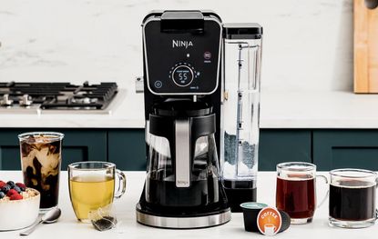 A Ninja DualBrew Pro on a countertop with four cups of coffee and tea