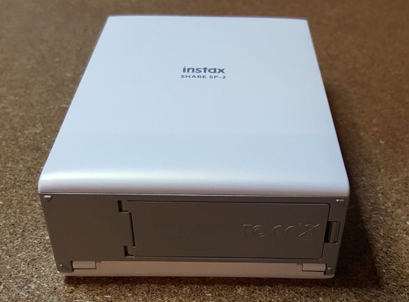 Fujifilm Instax SHARE SP-2 image: A cover on the bottom opens so you can load paper and remove the included battery.