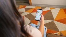 A woman checks her robo-adviser app on her phone.