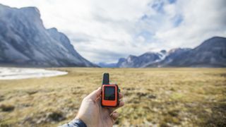 Adventurer holds mini GPS and satellite safety communication device