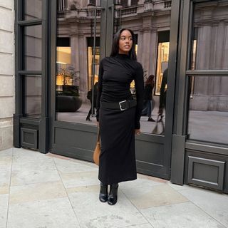 Influencer styles a draped dress with heeled boots.