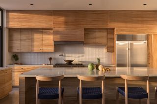 a wooden kitchen with fruit on the island