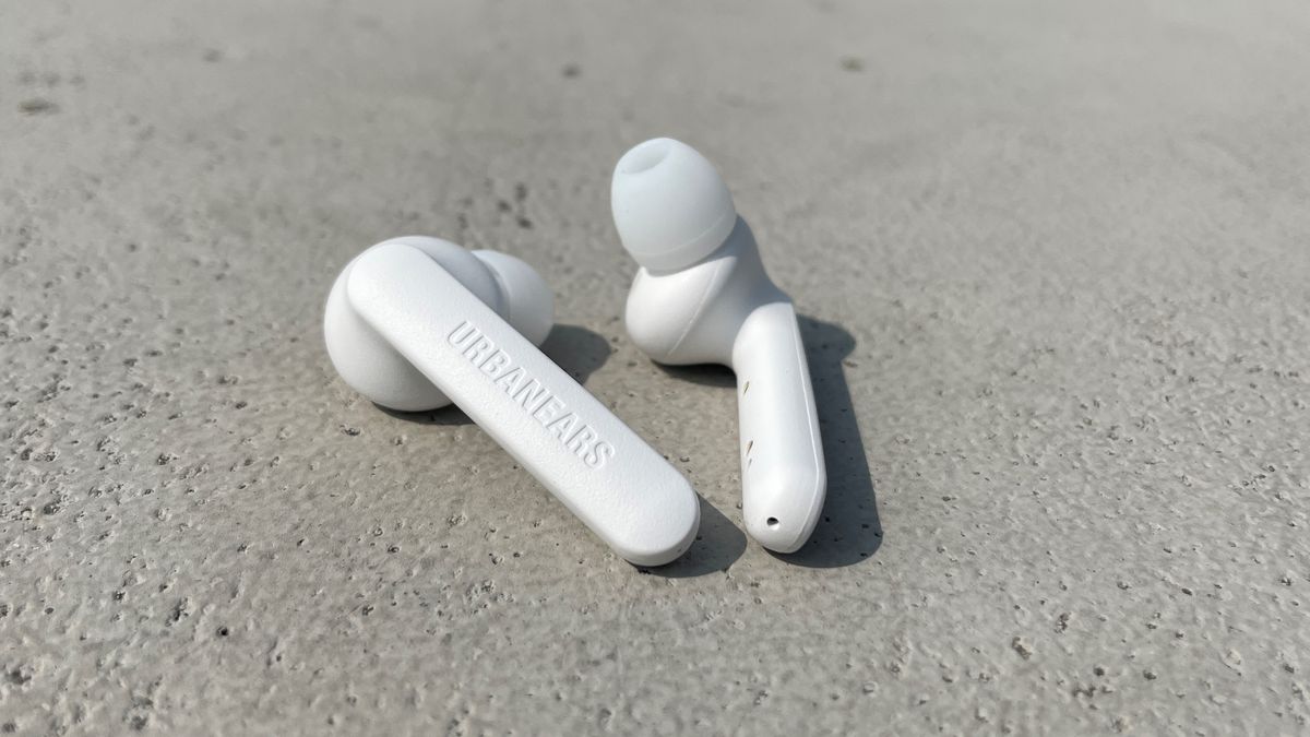 Urbanears Alby earbuds in white on a concrete surface