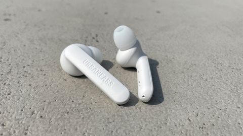 Urbanears Alby earbuds in white on a concrete surface