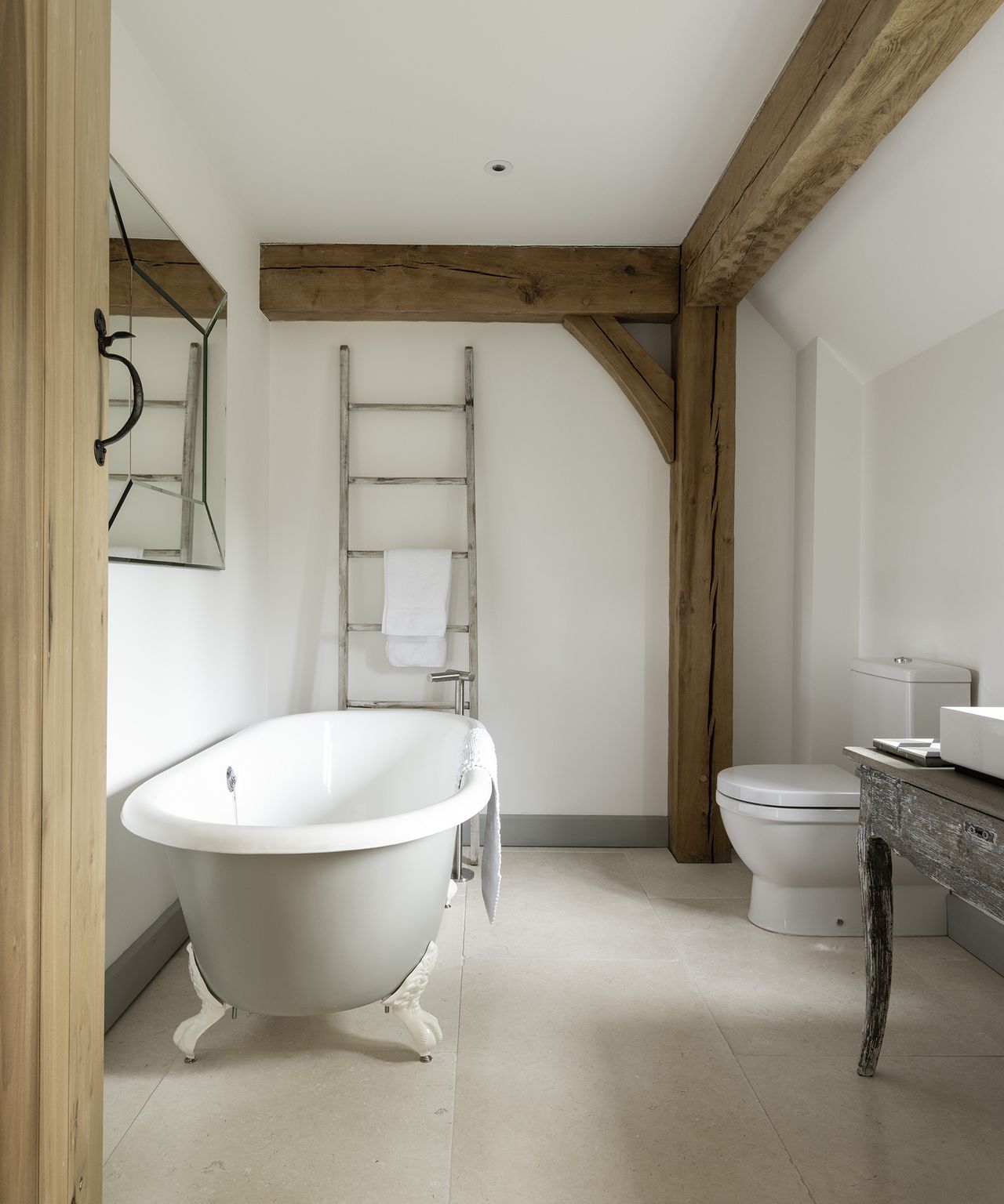 A medium-sized bathroom with a roll top bath with claw foot.