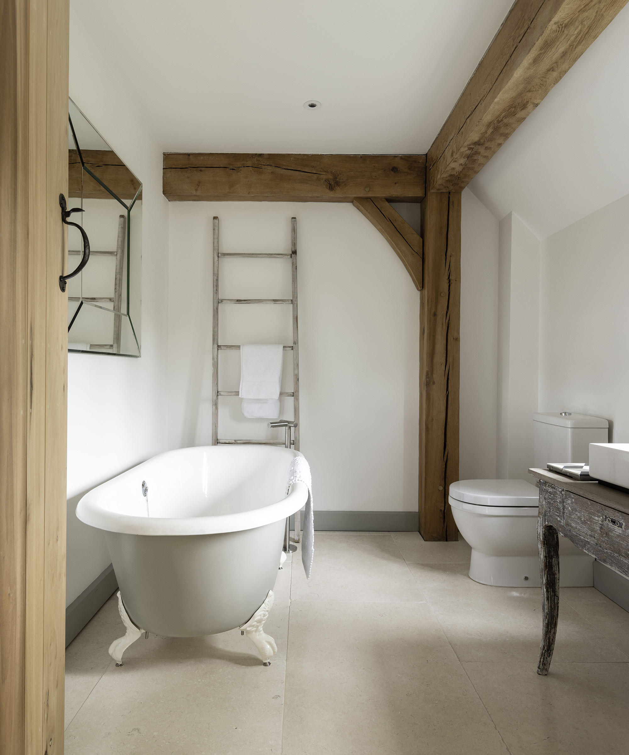 A medium-sized bathroom with a roll top bath with claw foot.
